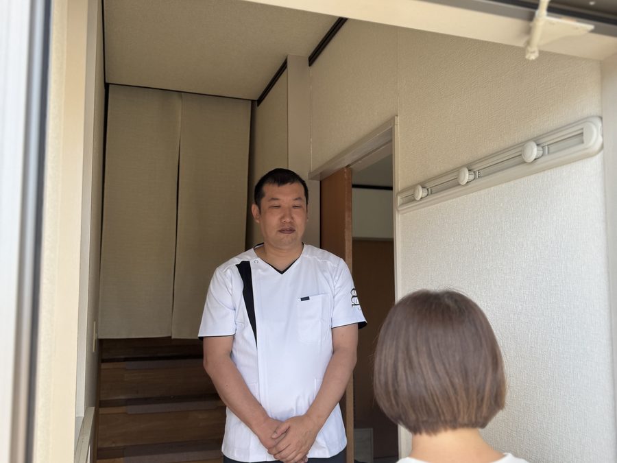 玄関でお迎えする院長